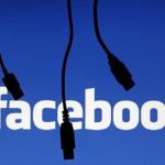 Electronic cables are silhouetted next to the logo of Facebook in this illustration photo in Sarajevo