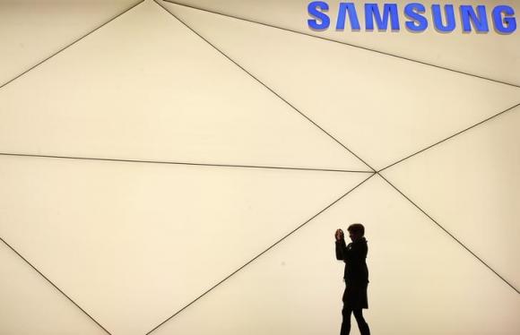 A woman takes a picture outside the Samsung stand at the Mobile World Congress in Barcelona