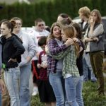 Two girls hug at Shoultes Gospel Hall church where families are reuniting after an active shooter situation at Marysville-Pilchuck High School in Marysville, Washington