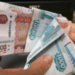 An employee counts Russian rouble banknotes at a small private shop in Krasnoyarsk