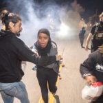 Protesters retreat while police officers deploy teargas to disperse a crowd comprised largely of student protesters during a protest against police violence in the U.S., in Berkeley