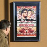 A man walks by poster for film "The Interview" outside Alamo Drafthouse theater in Littleton