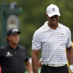 Woods grimaces after his tee shot on the 17th hole as Mickelson looks on during the second round of the PGA Championship at Valhalla Golf Club in Louisville