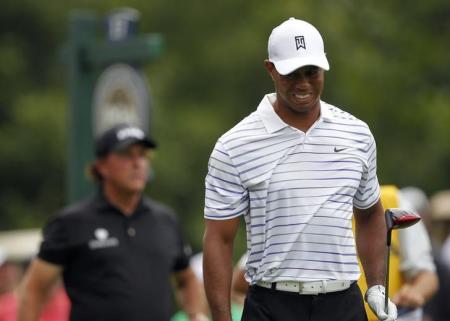 Woods grimaces after his tee shot on the 17th hole as Mickelson looks on during the second round of the PGA Championship at Valhalla Golf Club in Louisville