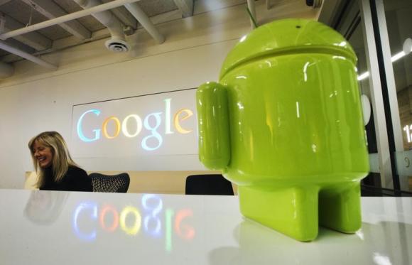 A Google Android figurine sits on the welcome desk as employee McNeilly smiles at the new Google office in Toronto