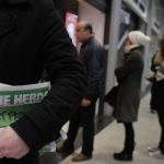 A man leaves after buying Charlie Hebdo newspapers