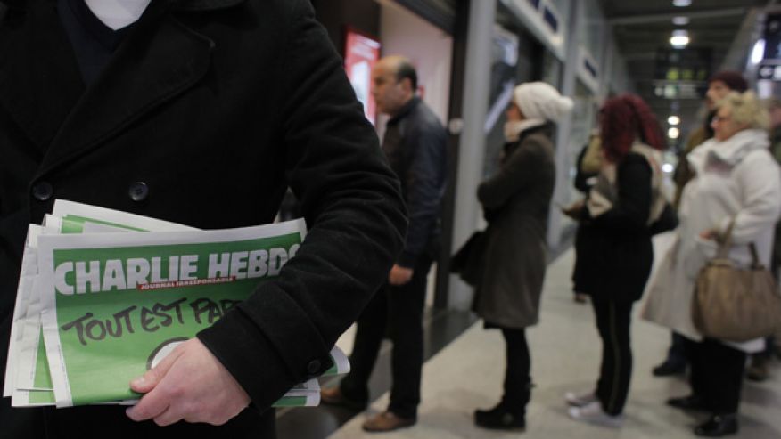 A man leaves after buying Charlie Hebdo newspapers
