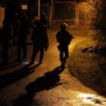 Armed police officers patrol in the village of Fleury