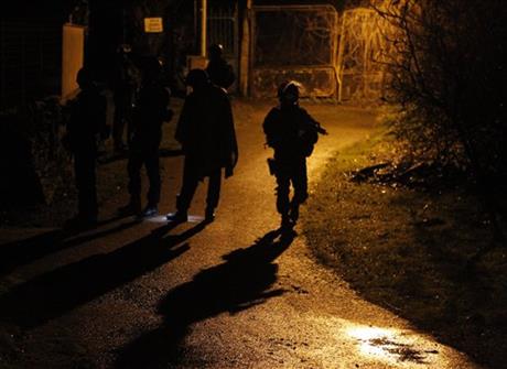 Armed police officers patrol in the village of Fleury