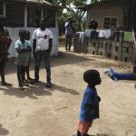 Health workers take temperature of boy who came in contact with woman who died of Ebola virus in Paynesville neighborhood of Monrovia
