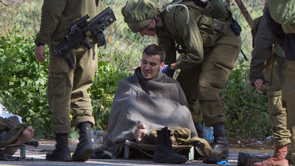 Israeli soldiers treat a wounded soldier