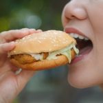 Woman Eating A Hamburger - by tiverylucky