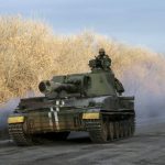 A Ukrainian serviceman rides on a self-propelled howitzer near Artemivsk