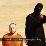 Still image from video shows a masked, black-clad militant, who has been identified by the Washington Post newspaper as Emwazi, standing next to a man purported to be Sotloff