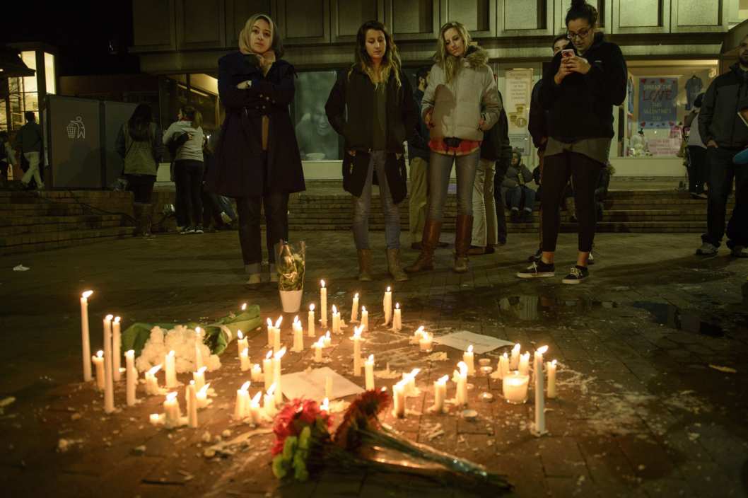 People before a makeshift memorial after a vigil at the University of North Carolina