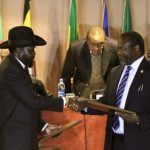 South Sudan's President Kiir and South Sudan's rebel commander Machar exchange documents fter signing a ceasefire agreement during the IGAD Summit in Addis Ababa