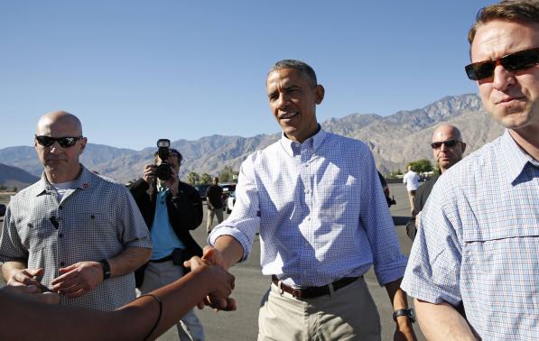 U.S. President Obama extends his hand to greet a well-wisher upon his arrival in Palm Springs