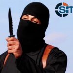 A masked, black-clad militant brandishes a knife in this still image from video