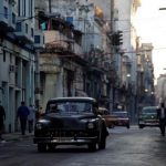 A car used as a taxi drives through the streets of Havana