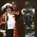 A ceremonial town crier announces the birth of a baby girl to royal fans and members of the media outside the entrance to the Lindo wing of St Mary's Hospital in London