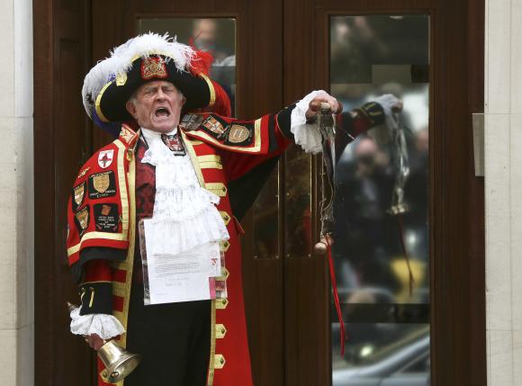 A ceremonial town crier announces the birth of a baby girl to royal fans and members of the media outside the entrance to the Lindo wing of St Mary's Hospital in London