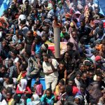 A group of 300 sub-Saharan Africans sit in board a boat during a rescue operation by the Italian Finance Police vessel Di Bartolo off the coast of Sicily