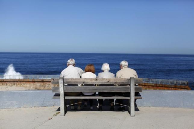 Elderly couples view the ocean and waves along the beach in La Jolla