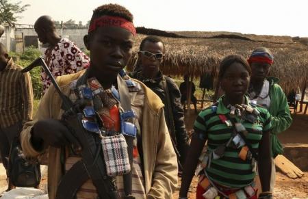An Anti-balaka child soldier wears lucky charms around his neck while he poses for a picture in Ouengo district, 7th arrondissement in Bangui