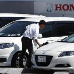 An employee wipes the surface of a car on display at a Honda dealer in Kawasaki, south of Tokyo