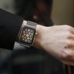 A customer presents his Apple Watch after buying it at a store in Paris