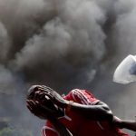 A detained protester cries in front of a burning barricade during a protest against President Pierre Nkurunziza's decision to run for a third term in Bujumbura
