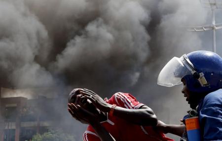 A detained protester cries in front of a burning barricade during a protest against President Pierre Nkurunziza's decision to run for a third term in Bujumbura