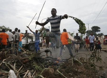 Protester jumps over a barricade during a protest against Burundi President Pierre Nkurunziza and his bid for a third term in Bujumbura