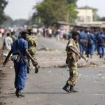 Policemen and soldiers walk on a street during a protest against Burundi President Pierre Nkurunziza and his bid for a third term in Bujumbura