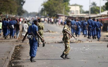 Policemen and soldiers walk on a street during a protest against Burundi President Pierre Nkurunziza and his bid for a third term in Bujumbura