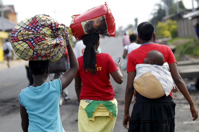 Women carry their belongings as they flee in fear of recent clashes between riot-policemen and protesters in Burundi's capital Bujumbura