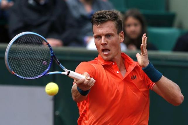Tomas Berdych of the Czech Republic plays a shot to Yoshihito Nishioka of Japan during their men's singles match at the French Open tennis tournament at the Roland Garros stadium in Paris