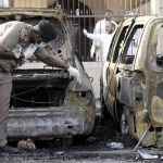 Policeman carries out an inspection after a car exploded near a Shi'ite mosque in Saudi Arabia's Dammam