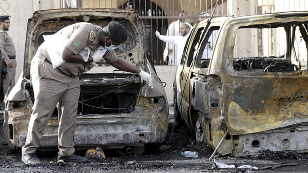 Policeman carries out an inspection after a car exploded near a Shi'ite mosque in Saudi Arabia's Dammam