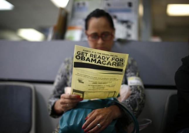 Murillo reads a leaflet at a health insurance enrollment event in Cudahy, California