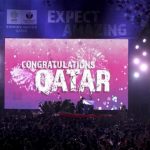 People celebrate in front of a screen that reads "Congratulations Qatar" after FIFA announced that Qatar will be host of the 2022 World Cup in Souq Waqif in Doha