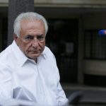 Former IMF head Dominique Strauss-Kahn enters his car as he leaves his apartment in Paris