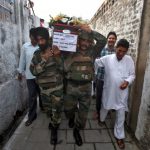 Indian army soldiers carry a coffin containing the body of their colleague Sat Pal Bhasin during his funeral on the outskirts of Jammu