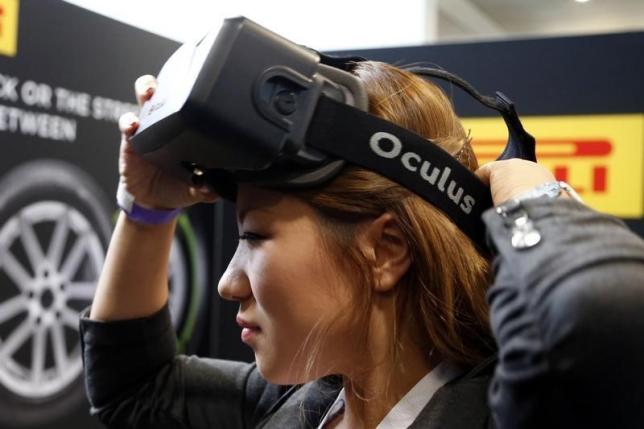 A woman puts on an Oculus virtual reality headset during preparations for the 2014 LA Auto Show in Los Angeles