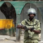 Riot policeman points his rifle towards protesters during a riot in Zanzibar