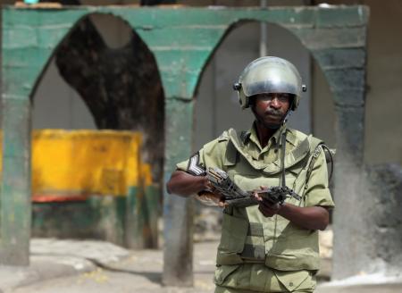 Riot policeman points his rifle towards protesters during a riot in Zanzibar