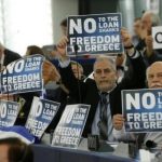 Members of the European Parliament hold placards which reads "No - Freedom to Greece" ahead of the speech of Greek Prime Minister Alexis Tsipras at the European Parliament in Strasbourg