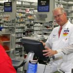 Pharmacy Manager at a Tampa, Florida Wal-Mart, completes a transaction with a customer