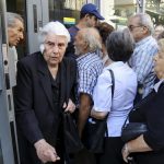 greece - People line up outside a National Bank branch
