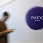 A man walks past a Yahoo logo during the Mobile World Congress in Barcelona